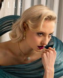 Woman with styled hair and makeup, wearing a blue top, in front of a curtain with 'ELLE' branding. Mara Megelea