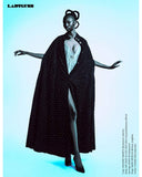Model wearing a black patterned dress with a plunging neckline on a light blue background. Mara Megelea