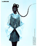 Model wearing a stylish outfit with a vest and long sleeves against a light blue background. Mara Megelea Ladygunn Magazine